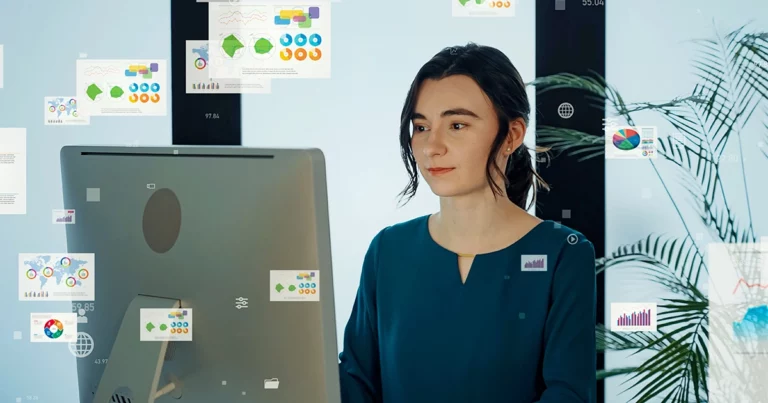 Femme analysant des données sur ordinateur avec des graphiques interactifs et des visualisations numériques flottantes, illustrant la digitalisation comptable et la transformation numérique.