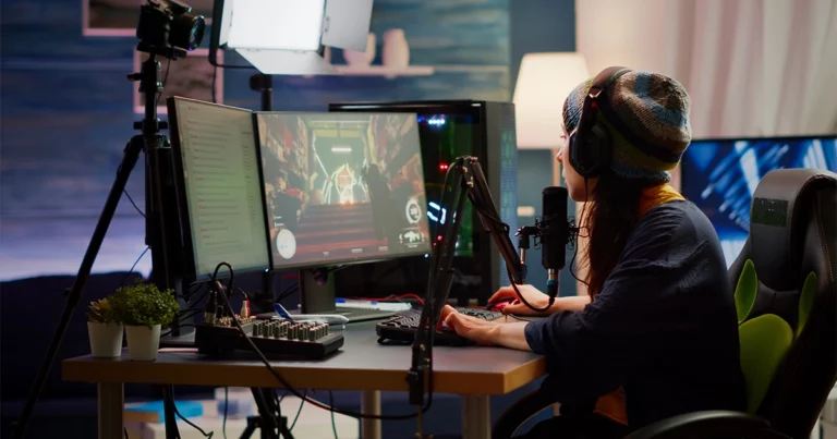 Une streameuse en direct sur Twitch, casque sur les oreilles, face à deux écrans et un micro