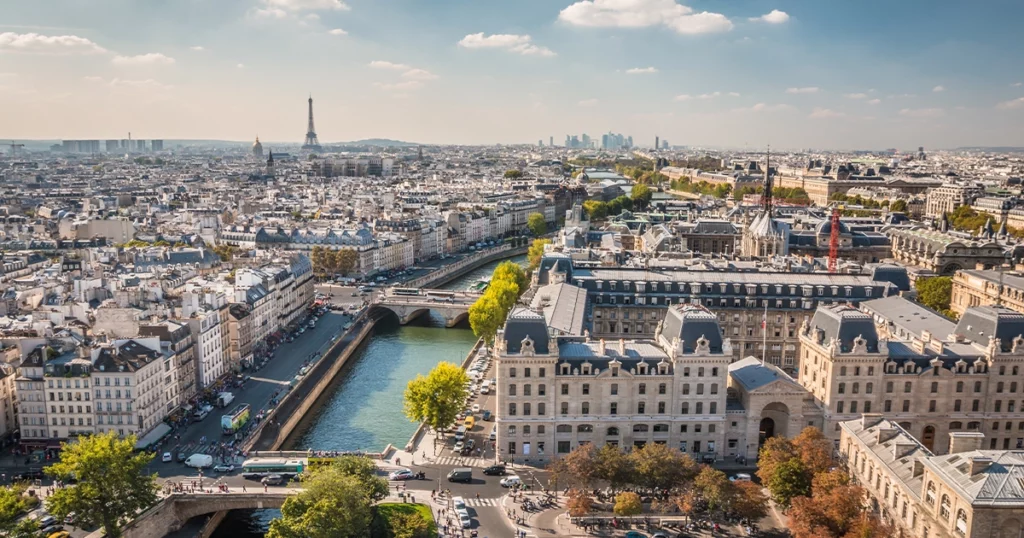ue panoramique sur Paris avec la Seine, la Tour Eiffel et le quartier d'affaires de La Défense, illustrant la zone d'intervention de l'intégrateur Pennylane certifié pour les PME franciliennes.