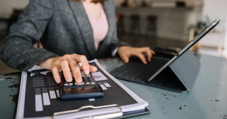 Comptable analysant des données financières en temps réel avec calculatrice et tablette pour optimiser le pilotage via la facture électronique
